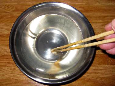 実験手順2: ステンレスボウル（どんぶりなどの瀬戸物でもよい）にマグカップ1杯半（約300 mL）程度の熱湯を注ぎ，ゼラチンの粉末約5 gを加えたのち，箸などでよくかき混ぜて溶かします。　＊やけどに注意