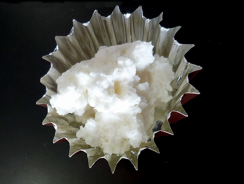 実験手順4: アルミカップに，固形物と5 cm程度に切ったたこ糸を入れ，約100℃に温めたホットプレートの上に置く。