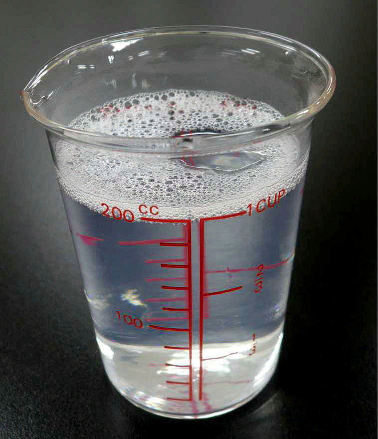 実験操作1: DNA抽出液（DNAを溶かし出す溶液）を作る　小さじ2杯の食塩，小さじ2杯の洗剤を計量カップに入れ，水を加えて全体を200 mLにして，よく混ぜる。半透明の溶液になっても構わないが，あまり泡立てないようにする。この液がDNAの抽出液になる。