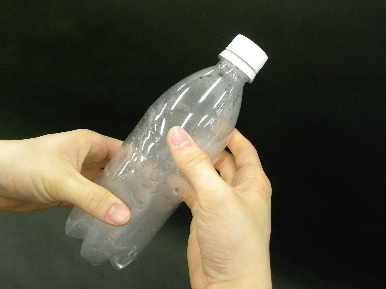 実験操作5: 手の力を一気にゆるめ，ペットボトルの形を元に戻す。　＊手の力を一気にゆるめると，ペットボトルの中が急に曇る。